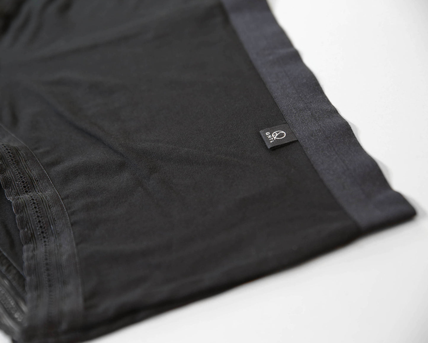 Closeup of the soft bamboo fabric and brand label with the QNTL logo.