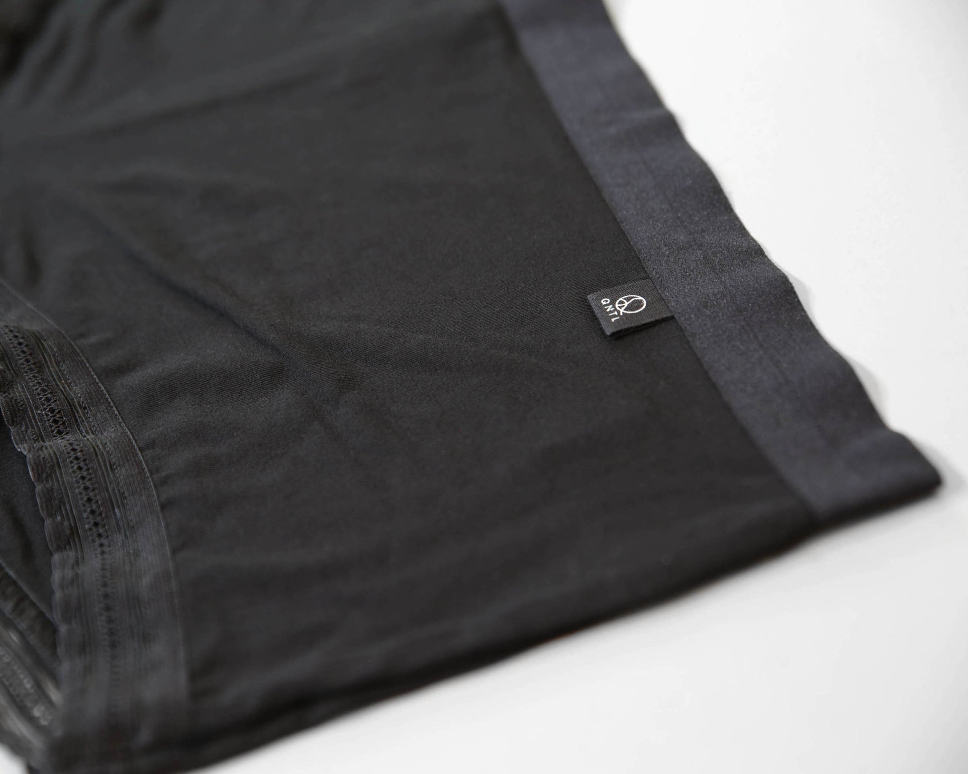 Closeup of the soft bamboo fabric on the front and brand label with the QNTL logo.