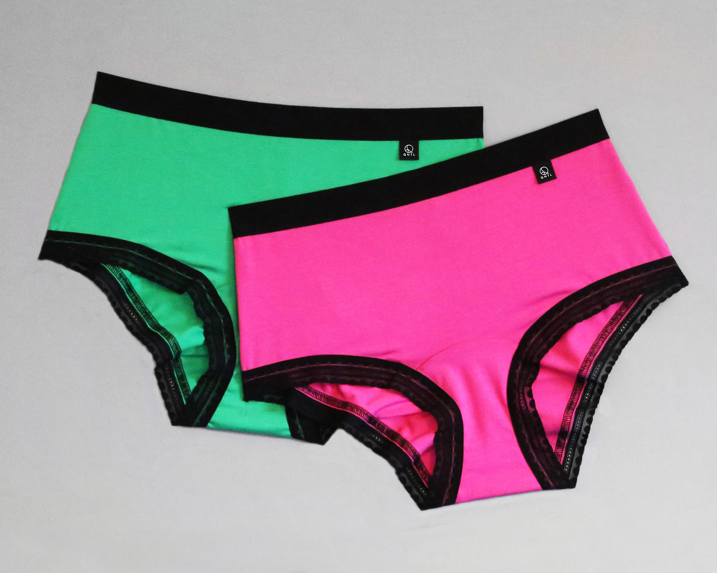 Full front view of samples of The Bamboo Hipster - Limited edition, with standard elastic in the leg opening. One sample is Green and the second is Pink, both with black coloured trims.