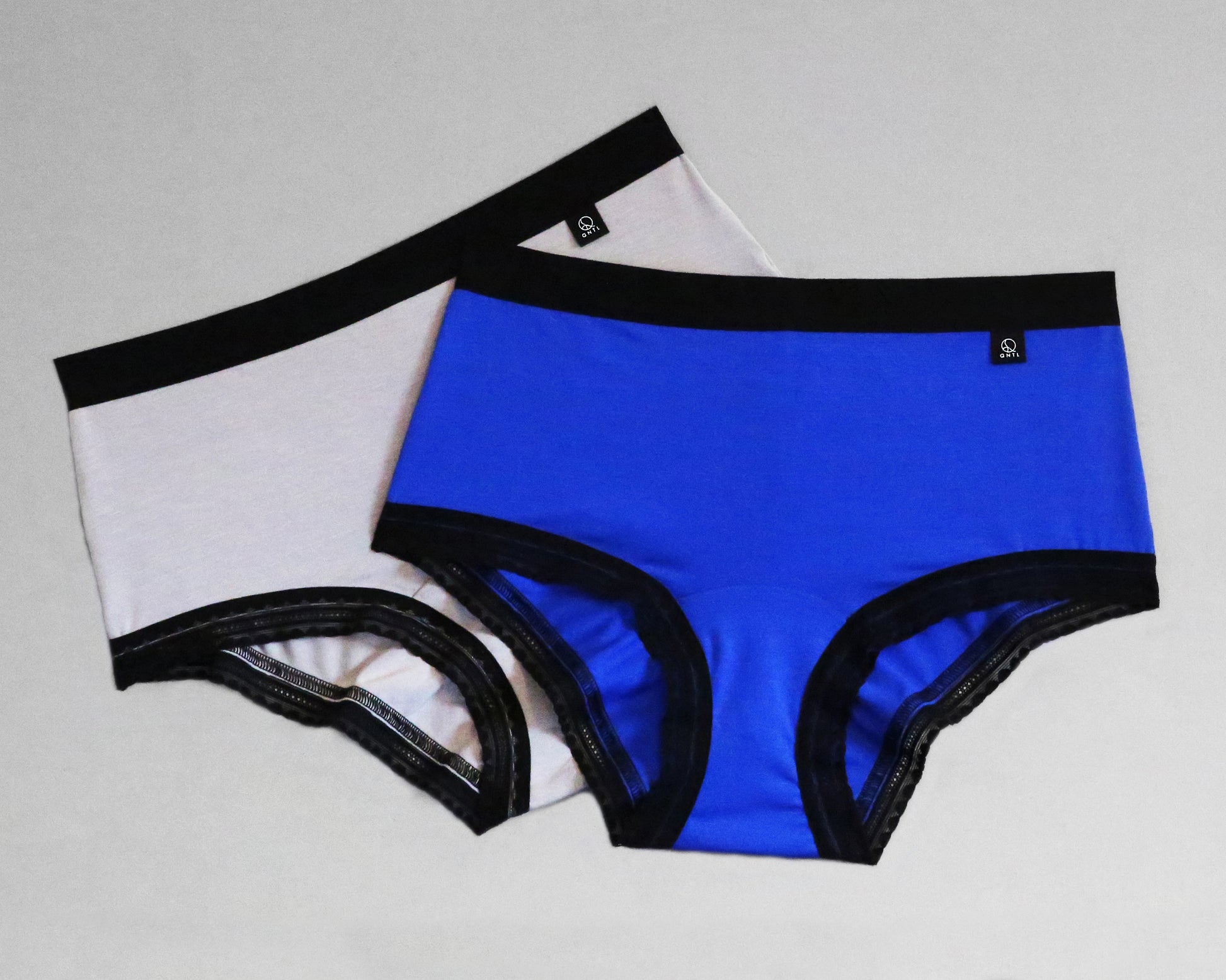 Full front view of samples of The Bamboo Hipster - Limited Edition, with standard elastic in the leg opening. One sample is Light Grey and the second is Blue, both with black coloured trims.