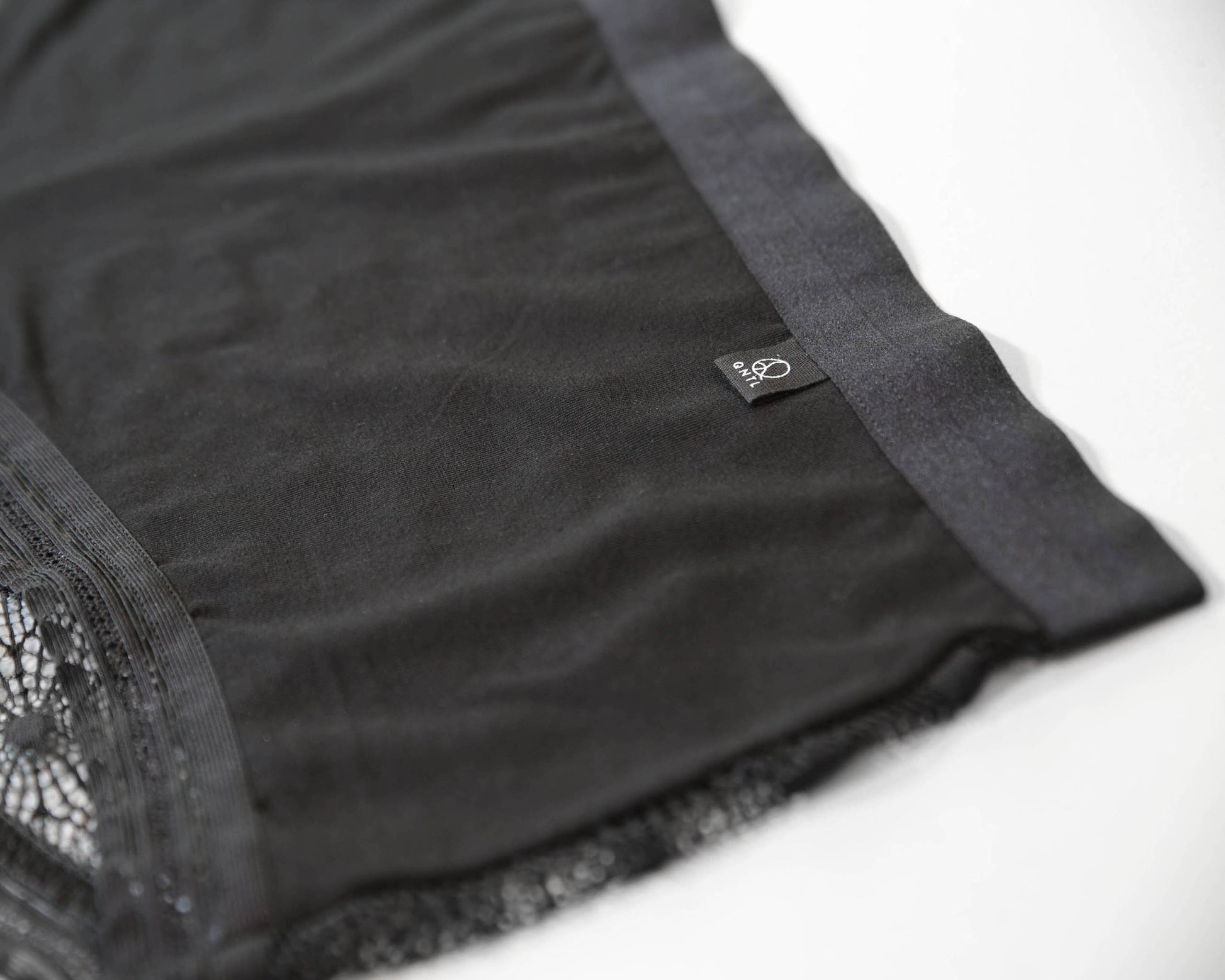 Closeup of the soft bamboo fabric on the front and brand label with the QNTL logo.